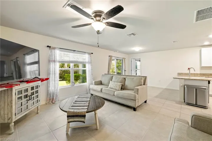 Living room featuring light tile patterned flooring and a ceiling fan