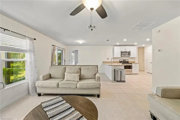 Living area with light tile patterned floors, recessed lighting, and ceiling fan