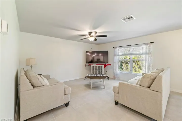 Living area with light tile patterned floors and a ceiling fan