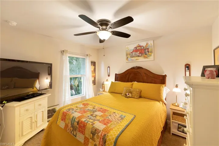 Bedroom featuring ceiling fan and dark carpet