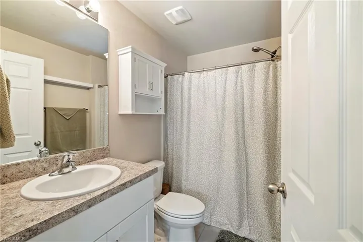 Bathroom featuring vanity and curtained shower