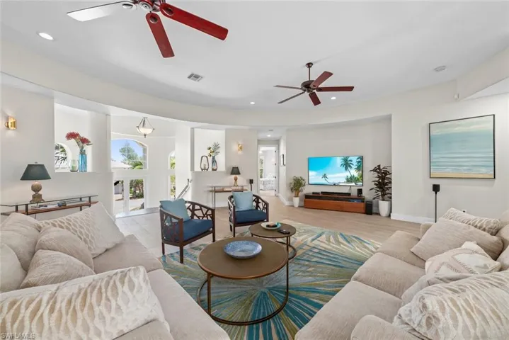 Spacious living area featuring curved walls and wood-finish flooring