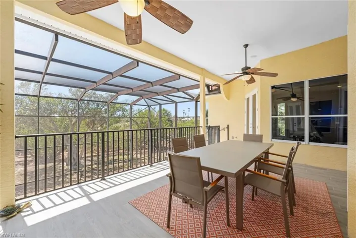 Screened outdoor living area featuring a light-colored tile floor, a ceiling fan, and painted exterior walls