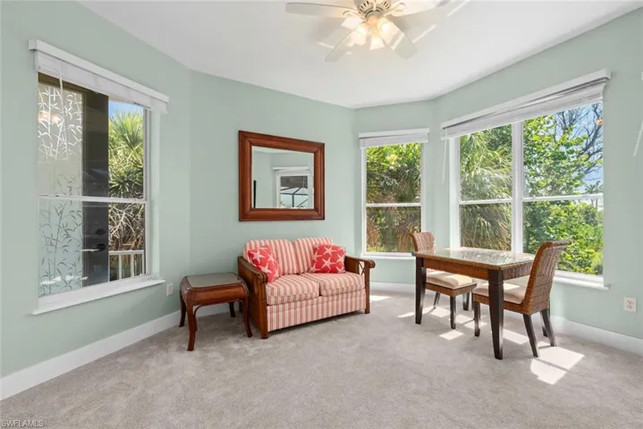 Carpeted interior space featuring light green walls and white trim