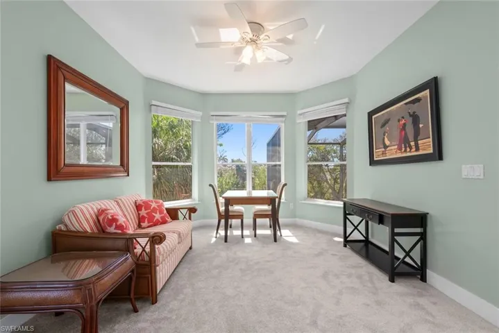 Room featuring a three-panel bay window, light green walls, and light gray carpeting