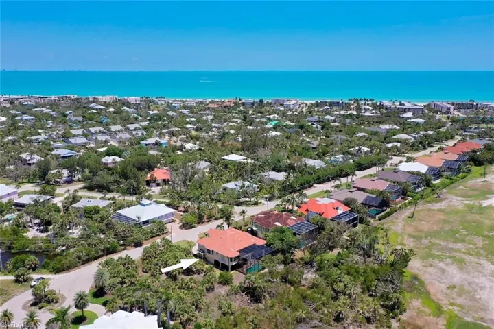 Coastal neighborhood featuring a variety of residential properties, tropical landscaping, and clear turquoise waters of the Gulf of Mexico