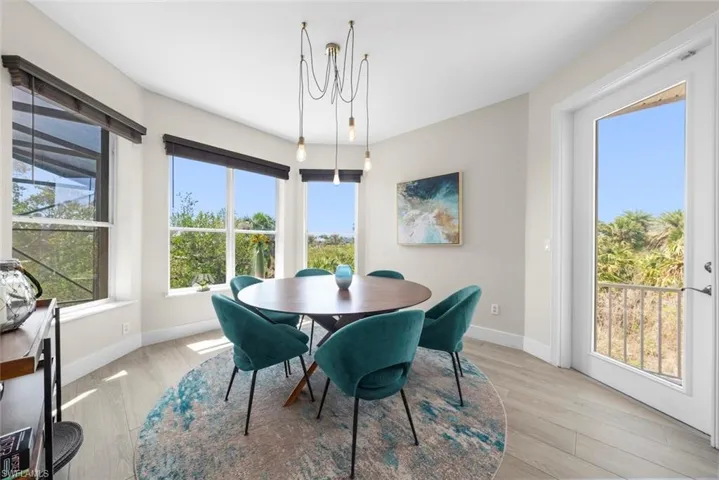 Dining area featuring a contemporary chandelier, multiple large windows, and a glass-paneled door
