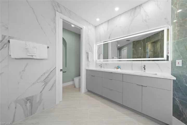 Dual vanity featuring gray cabinetry, integrated sinks, and polished chrome faucets