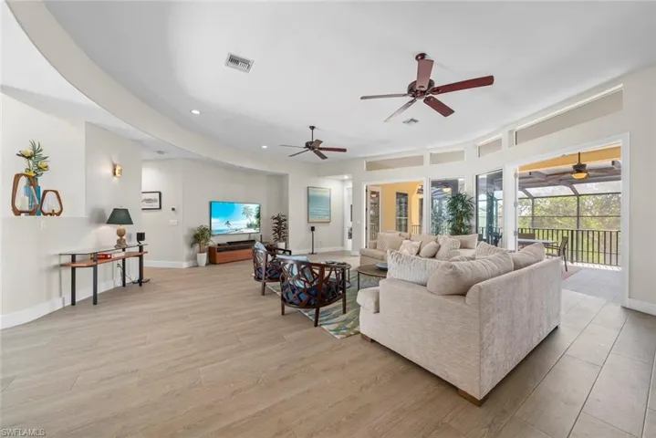 Expansive open concept living area featuring wood-finish flooring, recessed lighting, and multiple ceiling fans