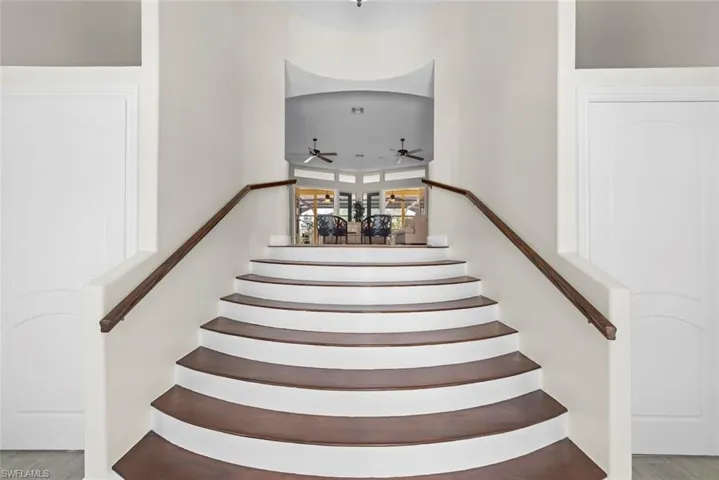 Grand curved staircase with wood-finish treads and white risers
