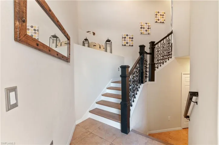 Stairs with tile patterned flooring and a high ceiling