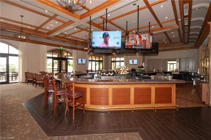 Bar with crown molding, a towering ceiling, a chandelier, and french doors