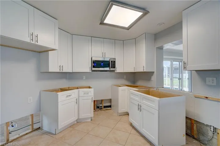 Kitchen featuring light tile patterned floors and white cabinetry