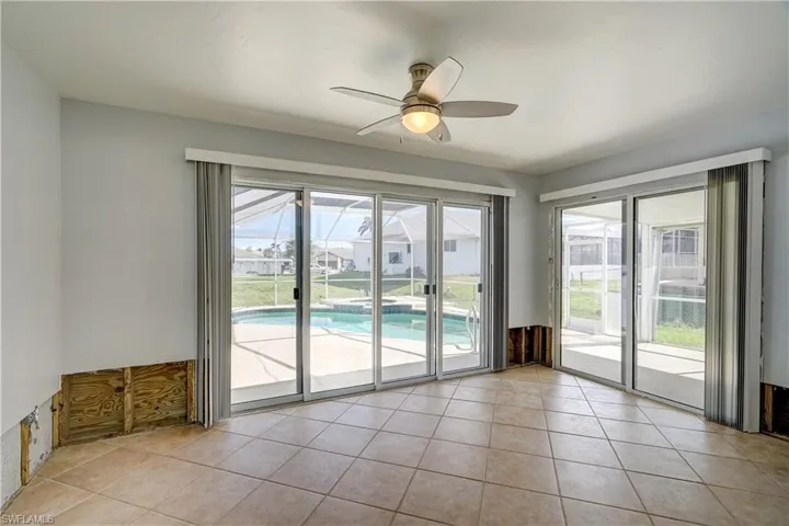 Doorway with ceiling fan and light tile patterned flooring