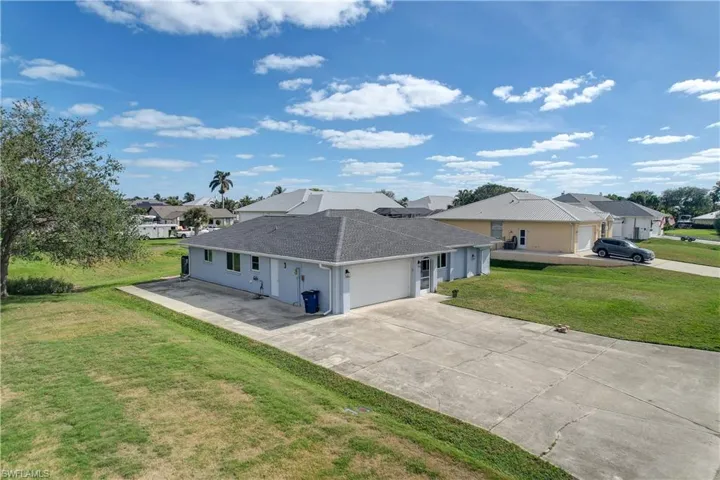 View of side of home featuring a yard and a garage