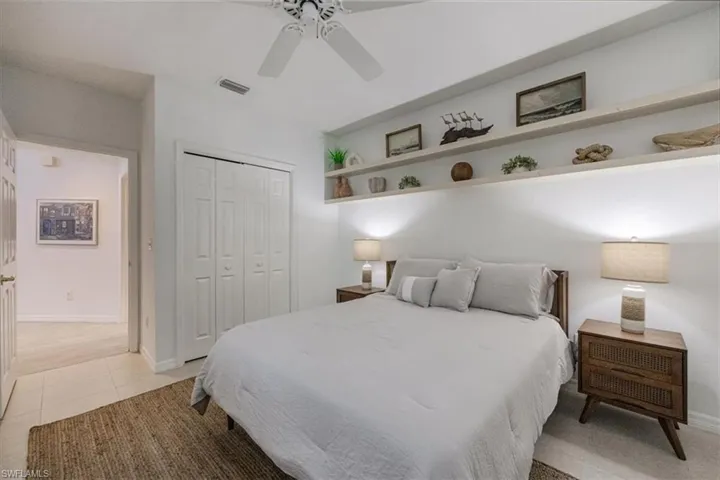 Bedroom featuring a closet, light tile patterned flooring, and ceiling fan