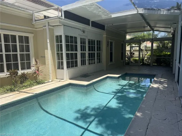Swimming pool featuring a patio area and glass enclosure