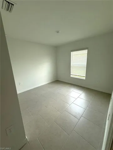 Unfurnished room featuring tile patterned floors and baseboards