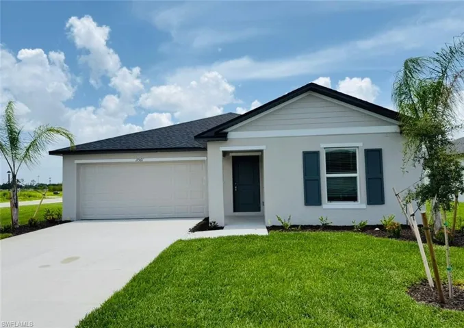 Ranch-style house with driveway, a garage, a front yard, and stucco siding