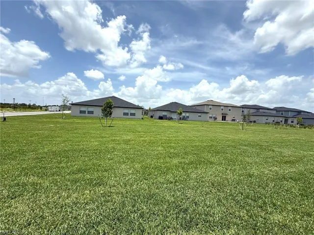 View of green lawn with a residential view