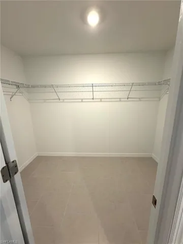 Walk in closet with light tile patterned floors