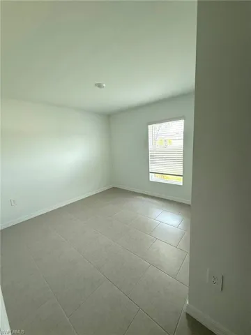 Unfurnished room with tile patterned flooring and baseboards