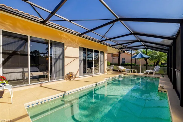 Swimming pool featuring a sunroom, a patio, and a lanai