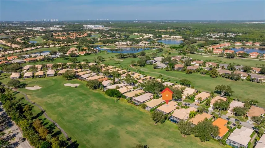 Aerial view of property and surrounding area with nearby suburban area, a golf course, and a large body of water