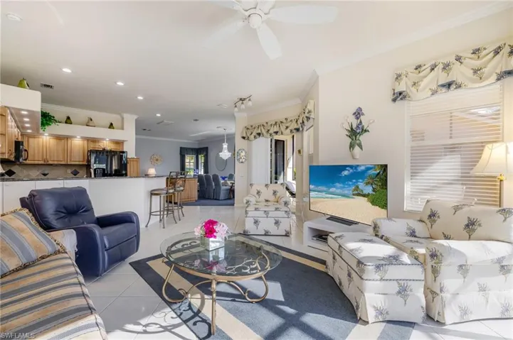Living area with light tile patterned floors, crown molding, a ceiling fan, and recessed lighting