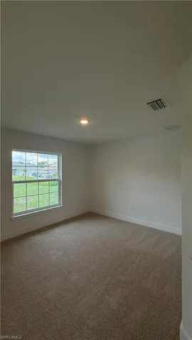 Neutral-toned carpeting extends throughout this room, complemented by white walls and trim