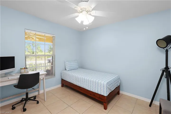 Bedroom with ceiling fan and light tile floors