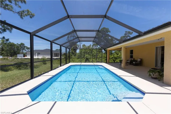View of swimming pool featuring a patio, a lanai, and a yard
