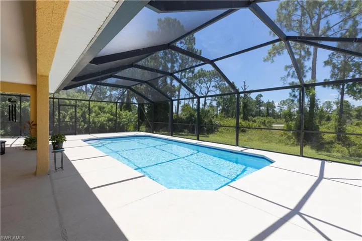View of swimming pool featuring a patio and a lanai