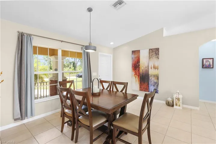 Tiled dining area with lofted ceiling