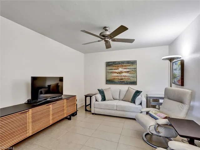 Living room featuring light tile patterned flooring and a ceiling fan