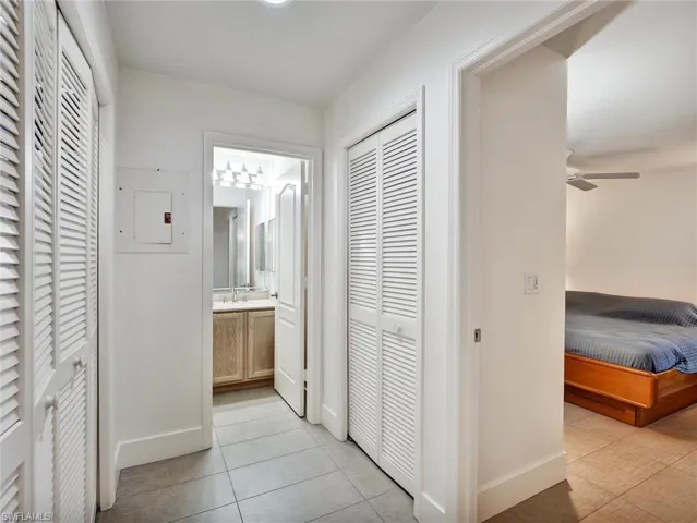 Hall with electric panel and light tile patterned floors