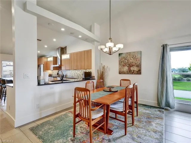 Dining space featuring plenty of natural light, a chandelier, light tile patterned flooring, recessed lighting, and high vaulted ceiling