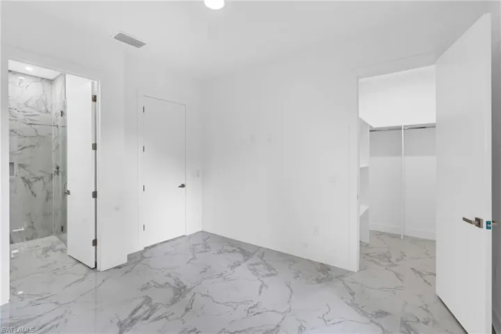 Bright interior space featuring white walls and white marble-look flooring