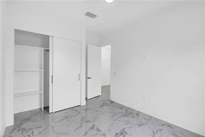 Room featuring white walls and a white ceiling with a single recessed light fixture