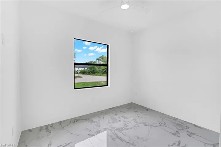 Bright interior space featuring large format marble-look tile flooring and crisp white walls