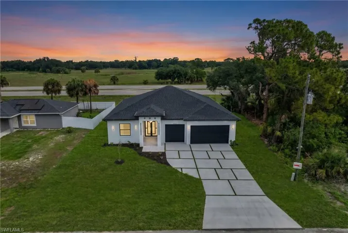 Contemporary single-story residence featuring a dark shingle roof and a light stucco exterior