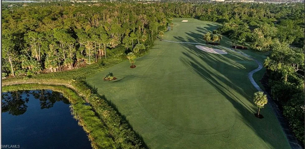 Aerial overview of property's location featuring a golf course and a nearby body of water