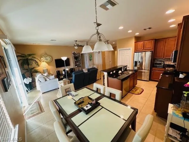 Dining space with light tile patterned flooring, a ceiling fan, and recessed lighting