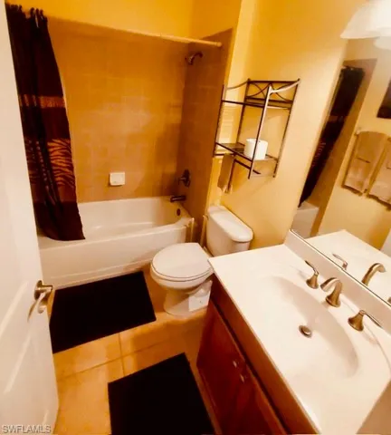Bathroom with vanity, shower / tub combo, and light tile patterned floors