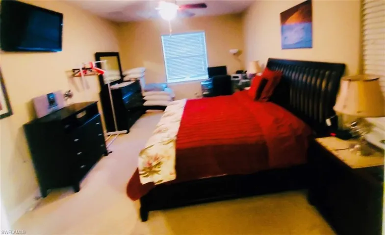 Bedroom featuring a ceiling fan and light carpet