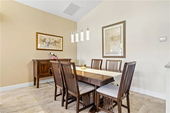 Dining room featuring lofted ceiling, visible vents, and baseboards