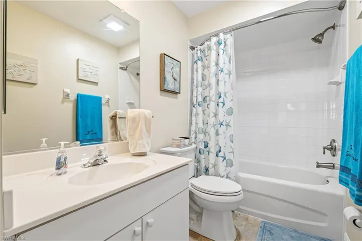 Bathroom with toilet, shower / bath combo, and vanity