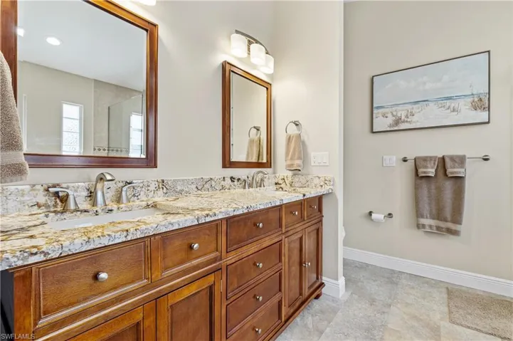 Full Master bath featuring double vanity, baseboards, and a sink