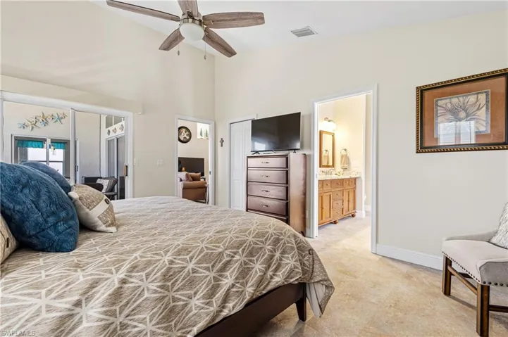 Bedroom featuring visible vents, a towering ceiling, connected bathroom, ceiling fan, and baseboards