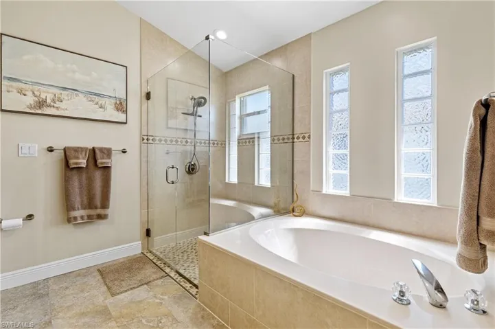 Bathroom with a stall shower, plenty of natural light, and a bath